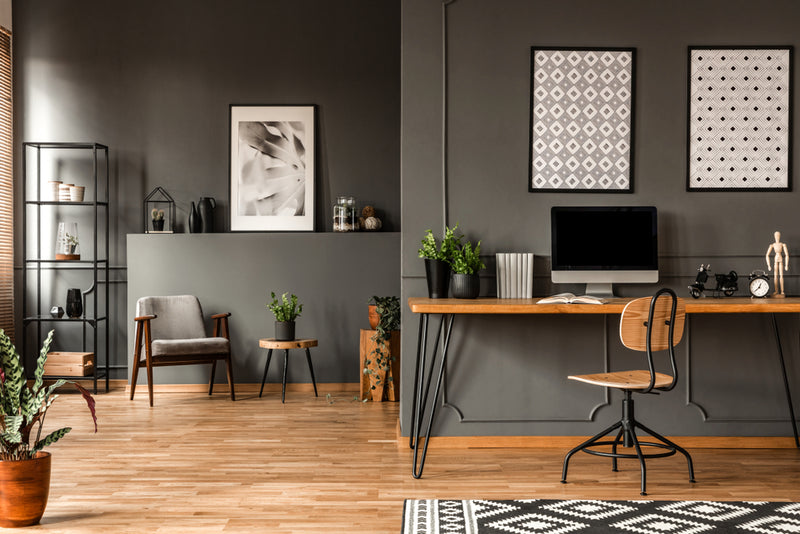 At home office in the living room. Grey walls with warm wooden floor and desk 