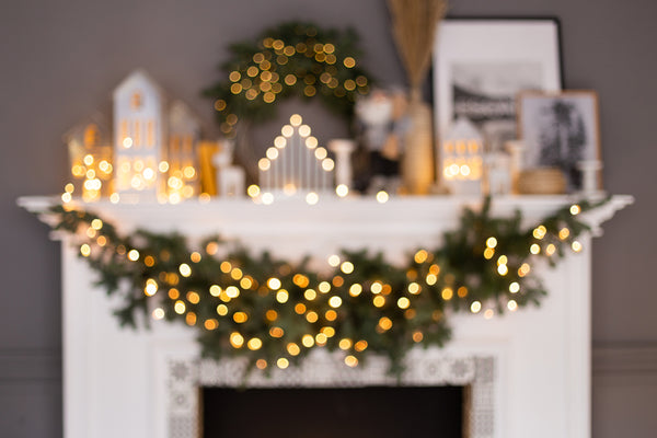 Christmas lit mantle scene with a festive garland hanging down