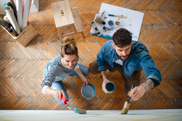 A man and a women painting a wall 